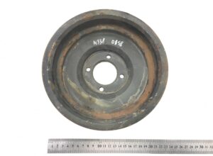 Központi lyukakkal és rozsdás széllel ellátott kb. 21 cm átmérőjű kör alakú fém alkatrész